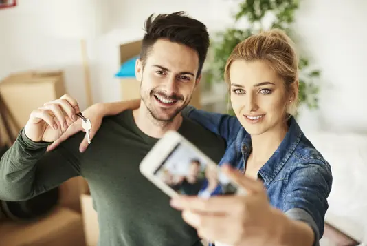 Paar macht Selfie mit Hausschlüssel.
